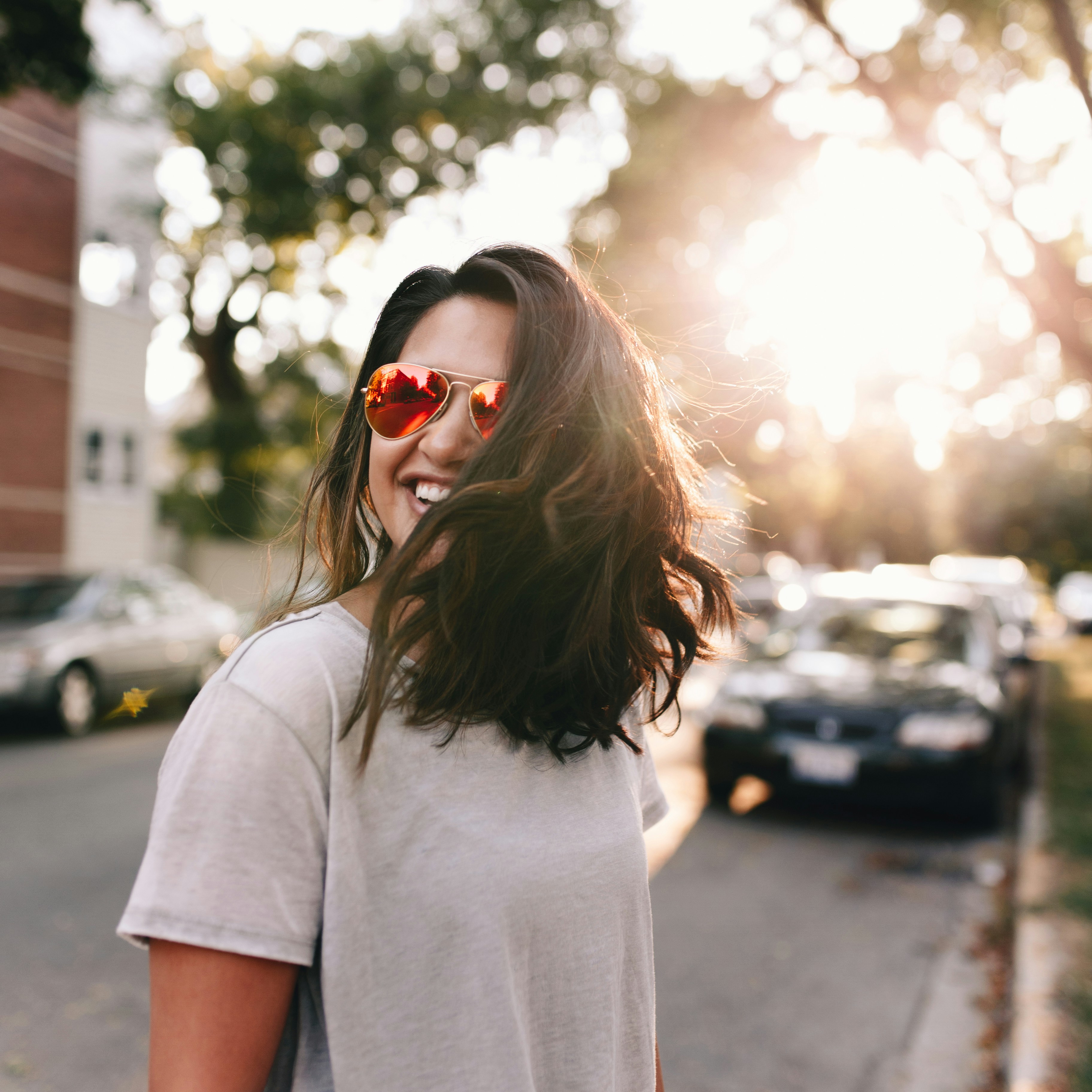 Woman wearing sunglasses outdoors in warm evening light